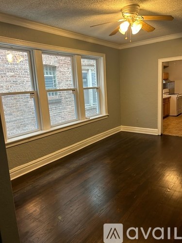 A room with a ceiling fan and wooden floors.