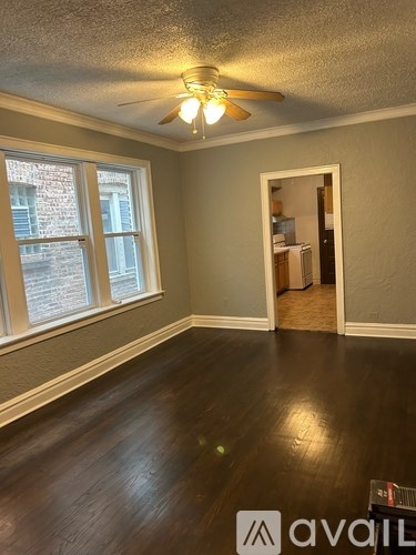 A room with a ceiling fan and a doorway leading to another room.