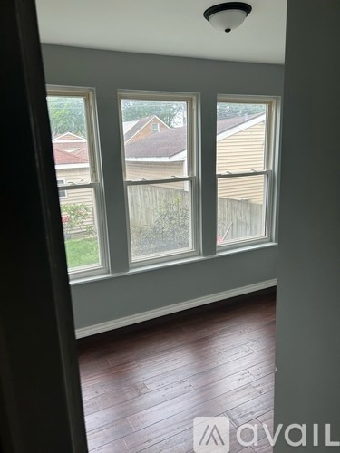 A room with a window overlooking a backyard.