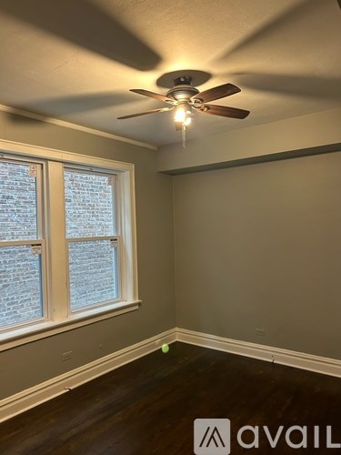 A room with a ceiling fan and a window.