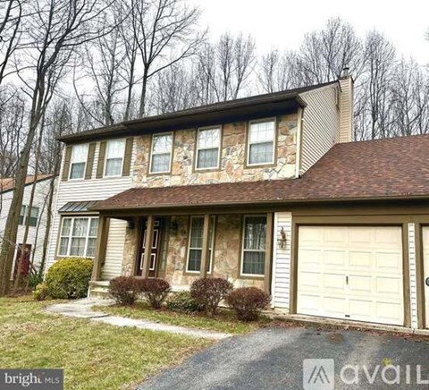 A two-story house with a garage is available for sale.