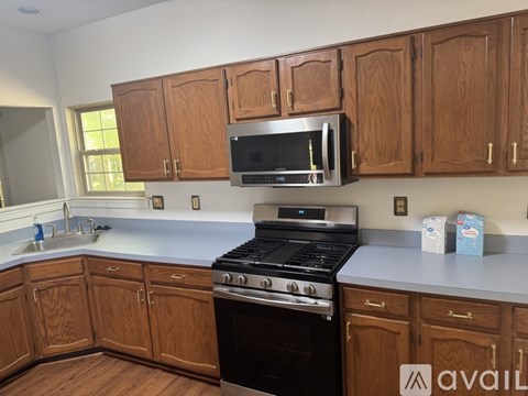 A kitchen with wooden cabinets and a black stove top oven.