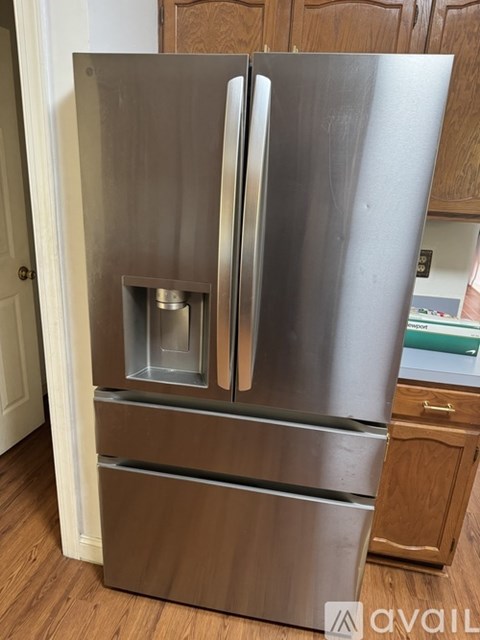 A stainless steel refrigerator with a freezer drawer and a water dispenser.