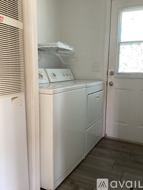 A white washing machine in a small room.