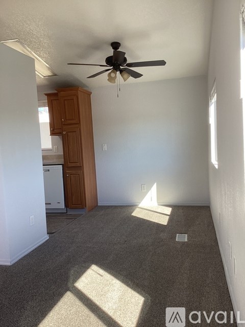 A room with a ceiling fan and a cabinet.