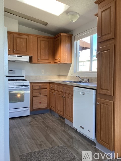A kitchen with wooden cabinets and a white dishwasher.
