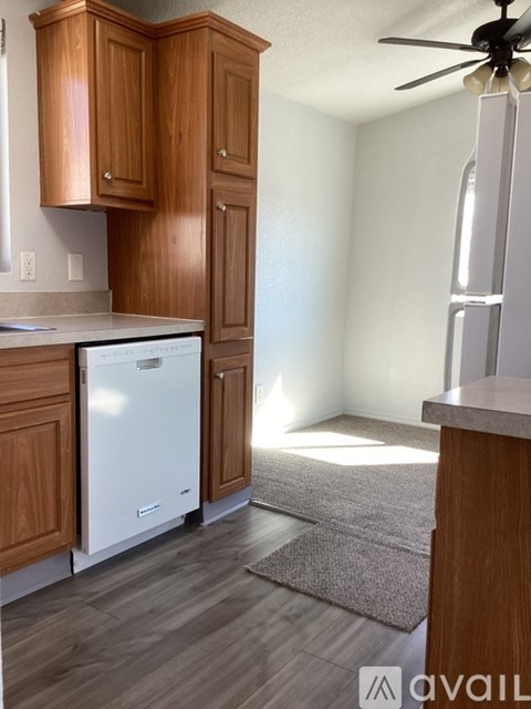 A kitchen with wooden cabinets and a white dishwasher.