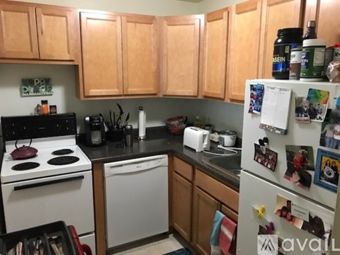 A kitchen with wooden cabinets and a white stove top oven.
