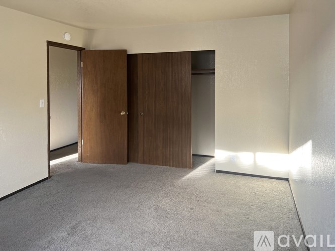 A room with a carpeted floor and a wall with a door and a window.