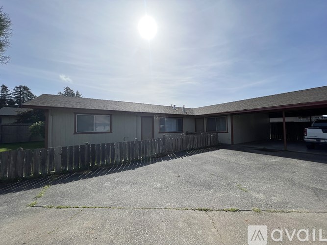 A sunny day at a parking lot with a building in the background.