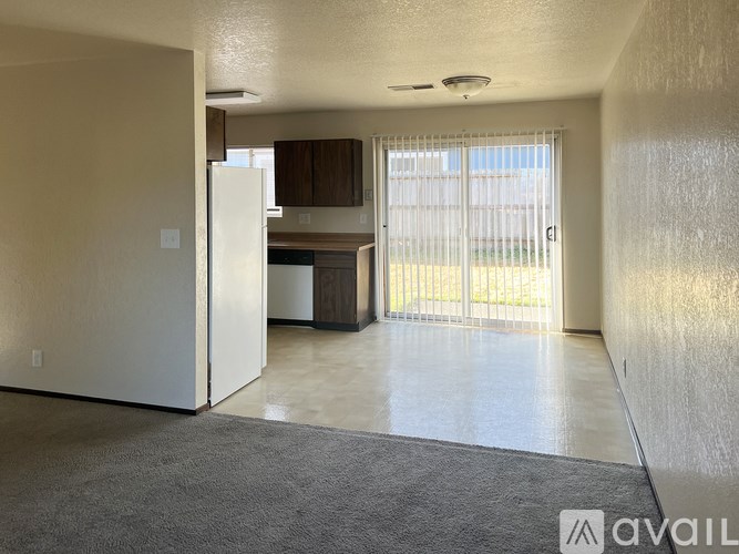 A spacious living room with a sliding glass door leading to a backyard.