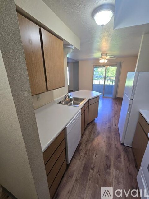 A kitchen with wooden cabinets and a white countertop.