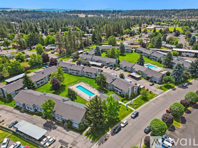 A bird's eye view of a residential area with houses, a swimming pool, and a road.