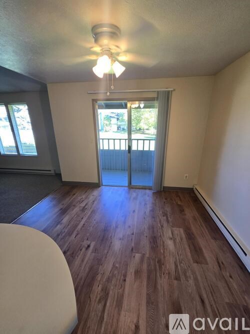 A room with wooden flooring and a ceiling fan.