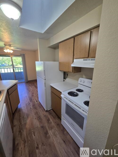A kitchen with white appliances and wooden cabinets.