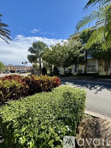 A street view with a building on the right and a tree in the middle.