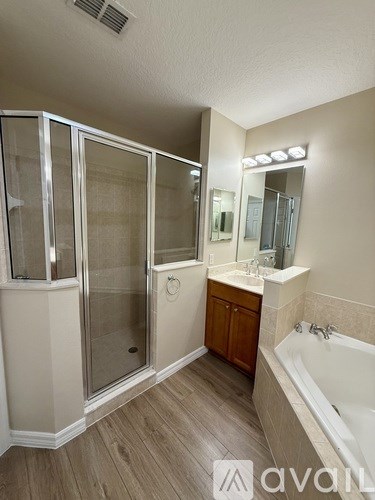 A bathroom with a tub, sink, and shower.
