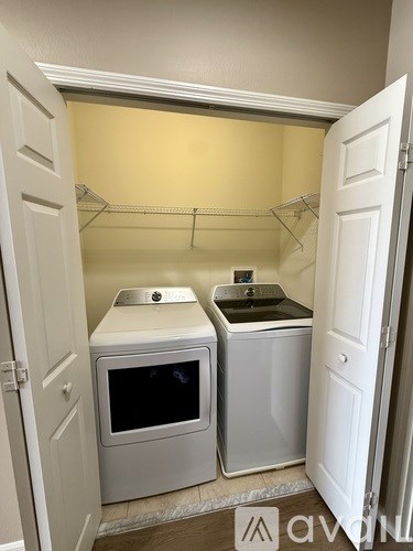 A small laundry room with a washer and dryer.