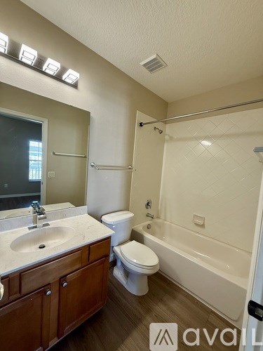 A bathroom with a sink, toilet, and bathtub.