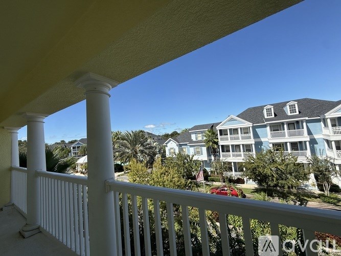 A balcony with a view of a row of houses and palm trees.