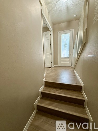 A staircase with wooden steps and white walls.