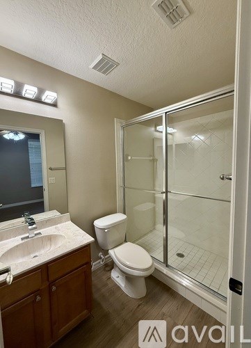 A bathroom with a toilet, sink, and shower.
