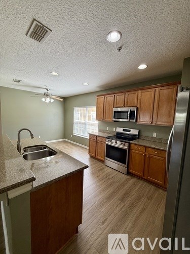 A kitchen with wooden cabinets and a granite countertop.