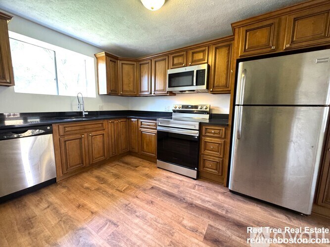 A kitchen with wooden cabinets and stainless steel appliances.