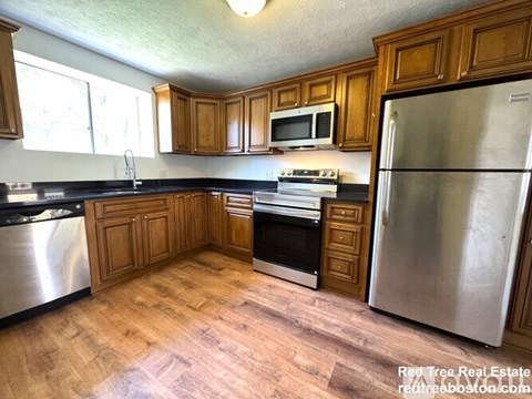 A kitchen with wooden cabinets and stainless steel appliances.