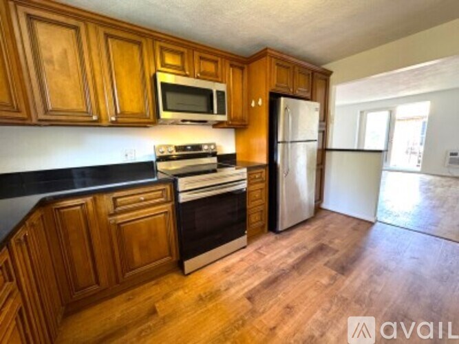 A kitchen with wooden cabinets and a black countertop.
