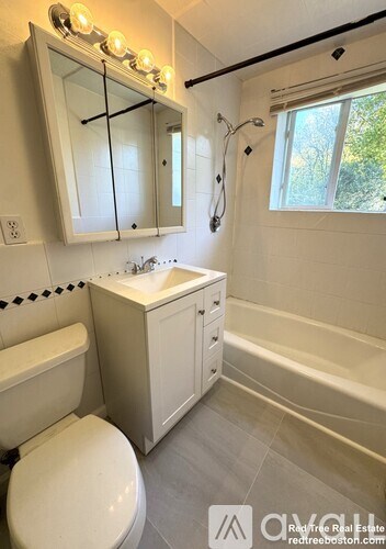 A white bathroom with a toilet, sink, and bathtub.