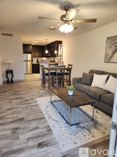 A living room with a couch, coffee table, and a dining table.