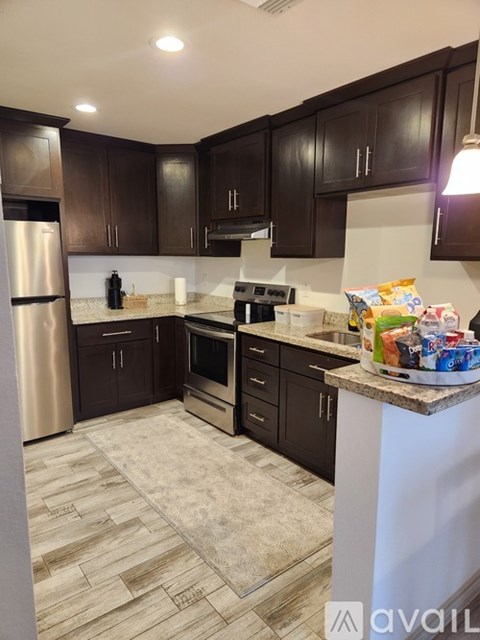 A kitchen with dark brown cabinets and a white island.