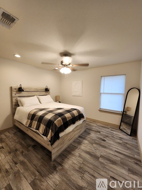 A bedroom with a bed, a ceiling fan, and a window.