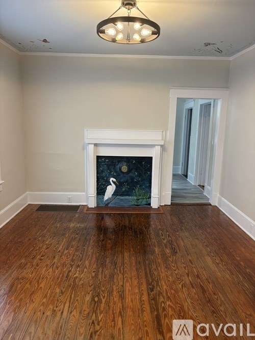 A room with a fireplace and wood flooring.