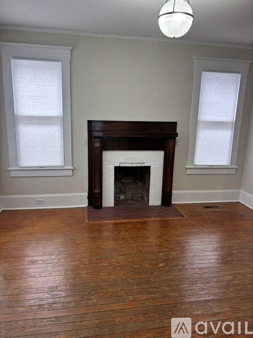 A room with a fireplace and wooden floors.