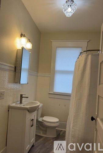A bathroom with a sink, toilet, and a window.