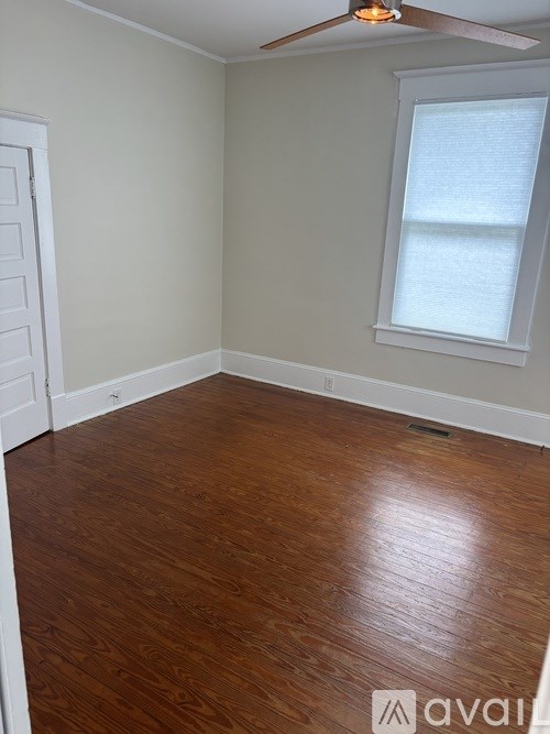 A room with wooden flooring and a window.