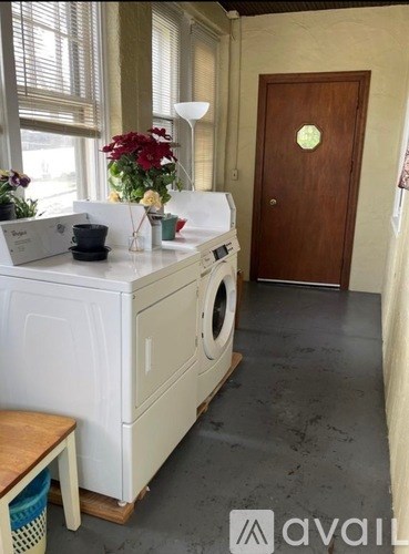 A small kitchen with a washing machine and a wooden door.