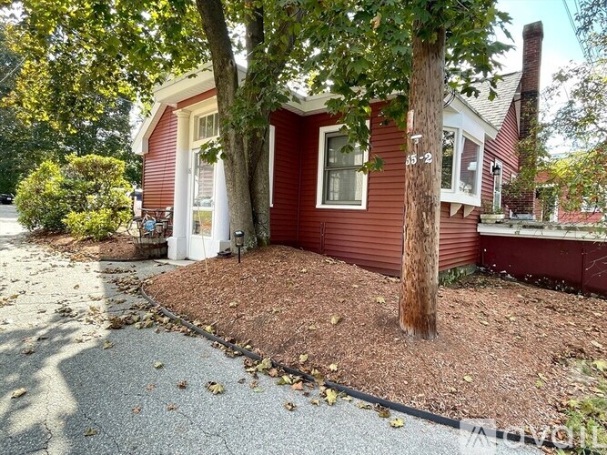 A red house with a tree in front of it.