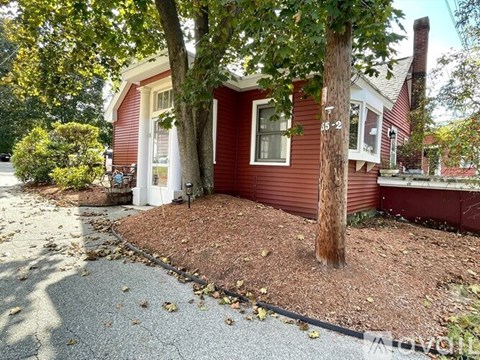 A red house with a tree in front of it.