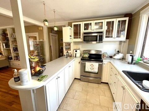 A kitchen with a white countertop and a stove top oven.