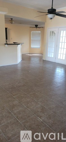 A living room with a ceiling fan and a large window.