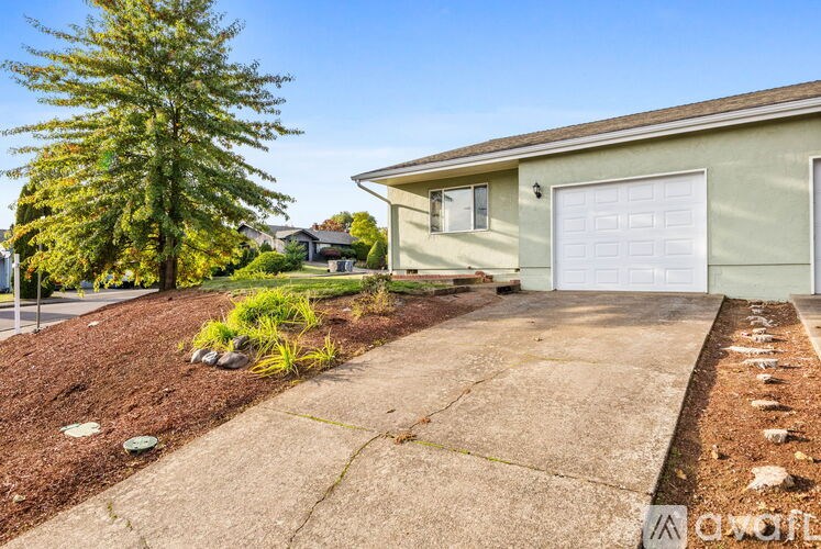 A house with a garage and a driveway in front of it.
