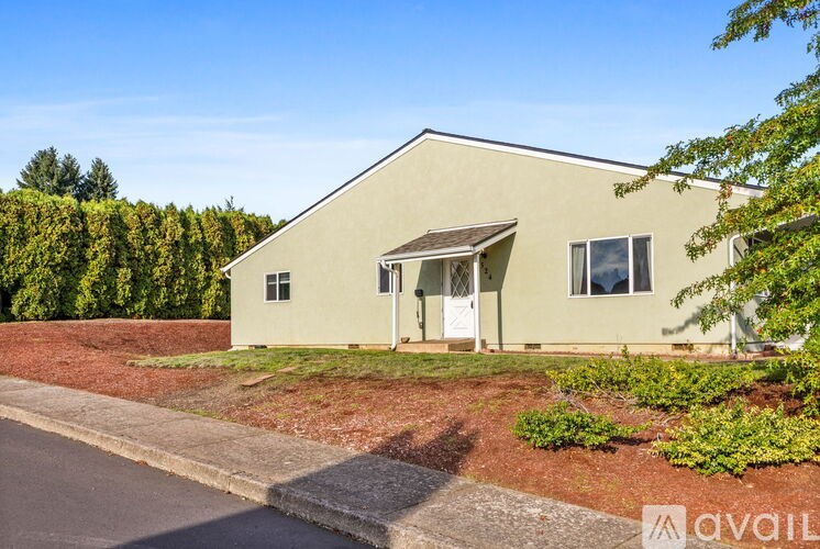 A house with a green lawn and trees in the background.