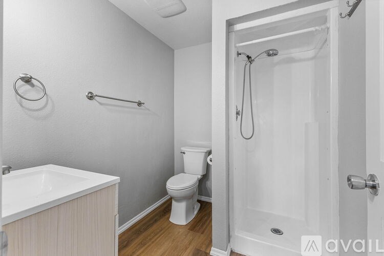 A white bathroom with a toilet, sink, and shower.