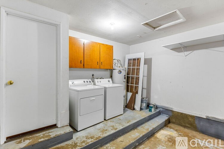 A bathroom with a white door, a white sink, and a white cabinet.