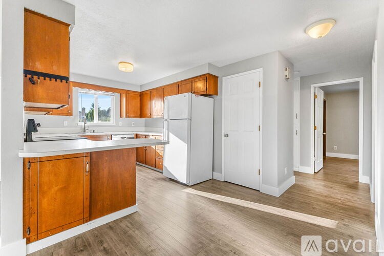 A kitchen with wooden cabinets and a white refrigerator.