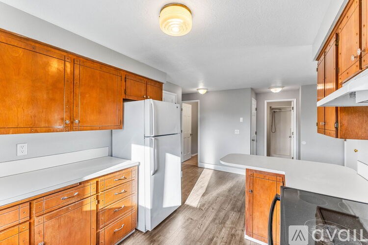 A kitchen with wooden cabinets and a white refrigerator.