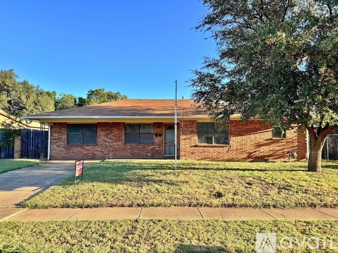 A red brick house with a flag in front.